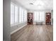 Bright living room featuring wood-look tile, white plantation shutters, and built-in bookcases at 5815 Pristine Falls Ave, Las Vegas, NV 89131