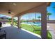 Covered patio overlooking a beautiful backyard with a pool, hammock, and palm trees for relaxation at 5815 Pristine Falls Ave, Las Vegas, NV 89131