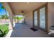 Covered patio with a ceiling fan, outdoor seating, and views of the lush backyard and pool area at 5815 Pristine Falls Ave, Las Vegas, NV 89131