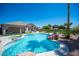 Large backyard pool and spa with rock waterfall feature, lush landscaping, and covered patio at 5815 Pristine Falls Ave, Las Vegas, NV 89131