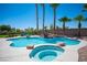 Backyard pool and spa with rock waterfall feature and lush landscaping including mature palm trees at 5815 Pristine Falls Ave, Las Vegas, NV 89131