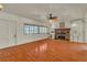 Cozy living room featuring a brick fireplace, built-in shelving, and hardwood floors at 5906 Bunch St, Las Vegas, NV 89122