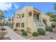 Beige two-story exterior with desert landscaping, patio, and a stairway to the 2nd level with black railings at 601 Cabrillo Cir # 754, Henderson, NV 89015