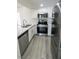 Updated kitchen featuring stainless steel appliances, quartz counters, white cabinets, and light hardwood floors at 601 Cabrillo Cir # 754, Henderson, NV 89015