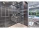 Modern bathroom with glass shower, dual sinks, and access to the outdoor pool and bedroom at 6103 Stone Rise St, Las Vegas, NV 89135