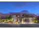 Stunning modern home exterior with a well-manicured yard and mountain backdrop at twilight at 6103 Stone Rise St, Las Vegas, NV 89135