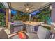 Entertain in style with an outdoor kitchen and grill under a covered patio, complemented by cozy seating and lush landscaping at 6103 Stone Rise St, Las Vegas, NV 89135