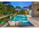 Beautiful backyard pool with water lounge chairs, lush landscaping, and fire features create a serene escape at 6103 Stone Rise St, Las Vegas, NV 89135