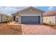 Charming single-story home featuring a brick driveway and a gray two-car garage door at 6755 Violet Cascade Ave, Las Vegas, NV 89156