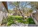 Landscaped backyard featuring pavers, artificial grass, mature trees and a fire pit area at 7687 W Pebble Rd, Las Vegas, NV 89113