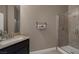 Bathroom features a walk-in shower with a glass door, tiled walls and a sink with black cabinets at 7687 W Pebble Rd, Las Vegas, NV 89113