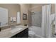 Bathroom features a shower-tub combo with tile surround, toilet, and dark vanity with light countertop at 7687 W Pebble Rd, Las Vegas, NV 89113