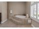 Bathroom featuring an oversized tub, tile surround, and natural light at 7687 W Pebble Rd, Las Vegas, NV 89113