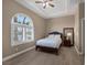 Bright bedroom with wood floors, a large arched window, and tray ceiling with a ceiling fan at 7687 W Pebble Rd, Las Vegas, NV 89113