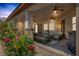 Covered patio with comfortable seating, ceiling fans and lush landscaping at 7687 W Pebble Rd, Las Vegas, NV 89113