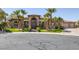 Stately front exterior of the home with palm trees and a circular driveway at 7687 W Pebble Rd, Las Vegas, NV 89113