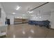 Spacious garage with epoxy flooring, overhead lighting, shelving, and ample space for parking and projects at 7687 W Pebble Rd, Las Vegas, NV 89113