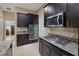 This kitchen features dark wood cabinets, granite countertops, stainless steel appliances and tile backsplash at 7687 W Pebble Rd, Las Vegas, NV 89113