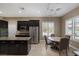 Well-equipped kitchen with stainless appliances, granite counters, dark cabinets, and a cozy breakfast nook for casual dining at 7687 W Pebble Rd, Las Vegas, NV 89113