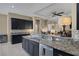 Modern kitchen featuring granite countertops, stylish black cabinets, stainless steel appliances, and an open-concept design at 7687 W Pebble Rd, Las Vegas, NV 89113