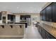 Modern kitchen features stainless appliances, dark wood cabinetry and granite countertops, open to the dining area at 7687 W Pebble Rd, Las Vegas, NV 89113