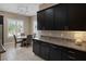 Charming kitchen nook featuring stainless steel appliances, dark cabinets, and a stylish backsplash and a dining set at 7687 W Pebble Rd, Las Vegas, NV 89113