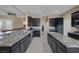 Gourmet kitchen featuring black cabinets, granite countertops, and stainless steel appliances, perfect for cooking and entertaining at 7687 W Pebble Rd, Las Vegas, NV 89113