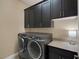 Laundry room with front loading washer and dryer and overhead cabinets at 7687 W Pebble Rd, Las Vegas, NV 89113