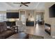 Open concept living area featuring cozy fireplace, ceiling fan, and stylish tile flooring throughout at 7687 W Pebble Rd, Las Vegas, NV 89113