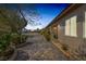 Side yard with lush landscaping and brick pathway leading to the patio at 7687 W Pebble Rd, Las Vegas, NV 89113