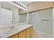 Bright bathroom featuring a large mirror, vanity, and tub-shower combination with sliding glass doors at 7901 Idledale Ct # 102, Las Vegas, NV 89145