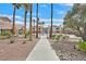 Community pool area with lush palm trees, seating, and well-maintained landscaping at 7901 Idledale Ct # 102, Las Vegas, NV 89145
