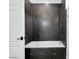 Modern bathroom showcasing dark tile with geometric accents and a sleek bathtub at 9 Greely Club Trl, Henderson, NV 89052