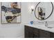 Modern powder room with round mirror, art, and marble countertop at 9 Greely Club Trl, Henderson, NV 89052