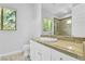 Bright bathroom with stone tile counter tops, toilet, sink, shower, and windows at 9 Greely Club Trl, Henderson, NV 89052