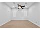 Large bedroom featuring neutral carpet, ceiling fan, and three windows at 9 Greely Club Trl, Henderson, NV 89052
