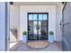Elegant double door entry with glass panels and stone accents, enhancing curb appeal at 9 Greely Club Trl, Henderson, NV 89052