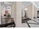Grand hallway with stone pillars, dark wood flooring, marble accents, and view of dining area with chandelier at 9 Greely Club Trl, Henderson, NV 89052
