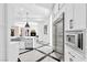 Modern kitchen featuring stainless steel appliances, custom cabinets, and marble floors at 9 Greely Club Trl, Henderson, NV 89052