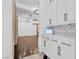 Bright kitchen featuring white cabinetry, zig-zag backsplash, and modern marble countertops at 9 Greely Club Trl, Henderson, NV 89052