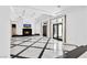 Open-concept living room featuring a fireplace, marble floors, and large glass doors at 9 Greely Club Trl, Henderson, NV 89052