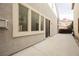 Spacious backyard patio with slider door and lush foliage near the side of the home at 9173 Whitekirk Pl, Las Vegas, NV 89145