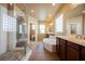Bright bathroom with a glass shower, large tub, and double vanity sinks at 9173 Whitekirk Pl, Las Vegas, NV 89145