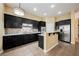 Stylish kitchen boasts dark cabinetry, stainless steel appliances, and a breakfast bar for casual dining at 9173 Whitekirk Pl, Las Vegas, NV 89145