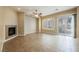 Spacious living room with a fireplace, tile flooring and a sliding door to the patio at 9173 Whitekirk Pl, Las Vegas, NV 89145