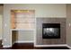 Living room featuring a fireplace, built-in bar and hardwood flooring at 9173 Whitekirk Pl, Las Vegas, NV 89145
