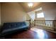 Loft area with a gray futon and hardwood floors at 9173 Whitekirk Pl, Las Vegas, NV 89145