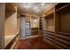 Spacious walk-in closet with custom shelves and drawers, and beautiful wood flooring at 9173 Whitekirk Pl, Las Vegas, NV 89145