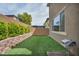 Manicured backyard featuring synthetic grass, brick retaining walls and garden at 9370 Burning Sage Ave, Las Vegas, NV 89149