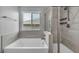 Modern bathroom featuring a soaking tub, shower with dual heads, and a window at 9370 Burning Sage Ave, Las Vegas, NV 89149